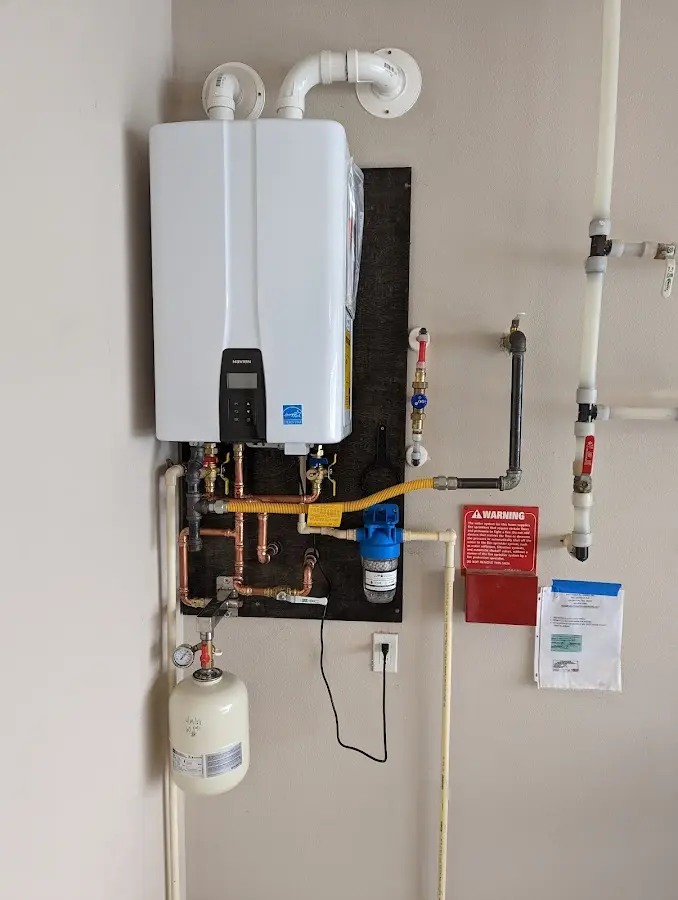 Professional plumber installing copper piping in a West Long Branch home